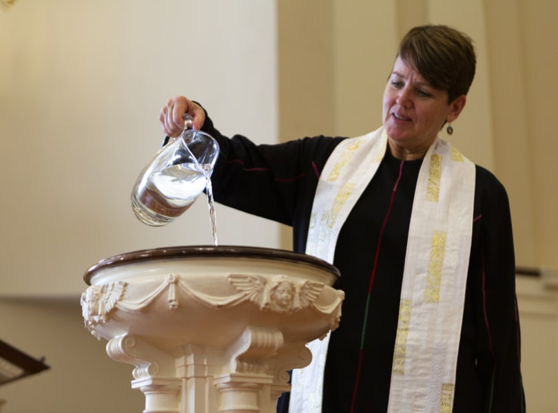 Pastor pours baptismal water