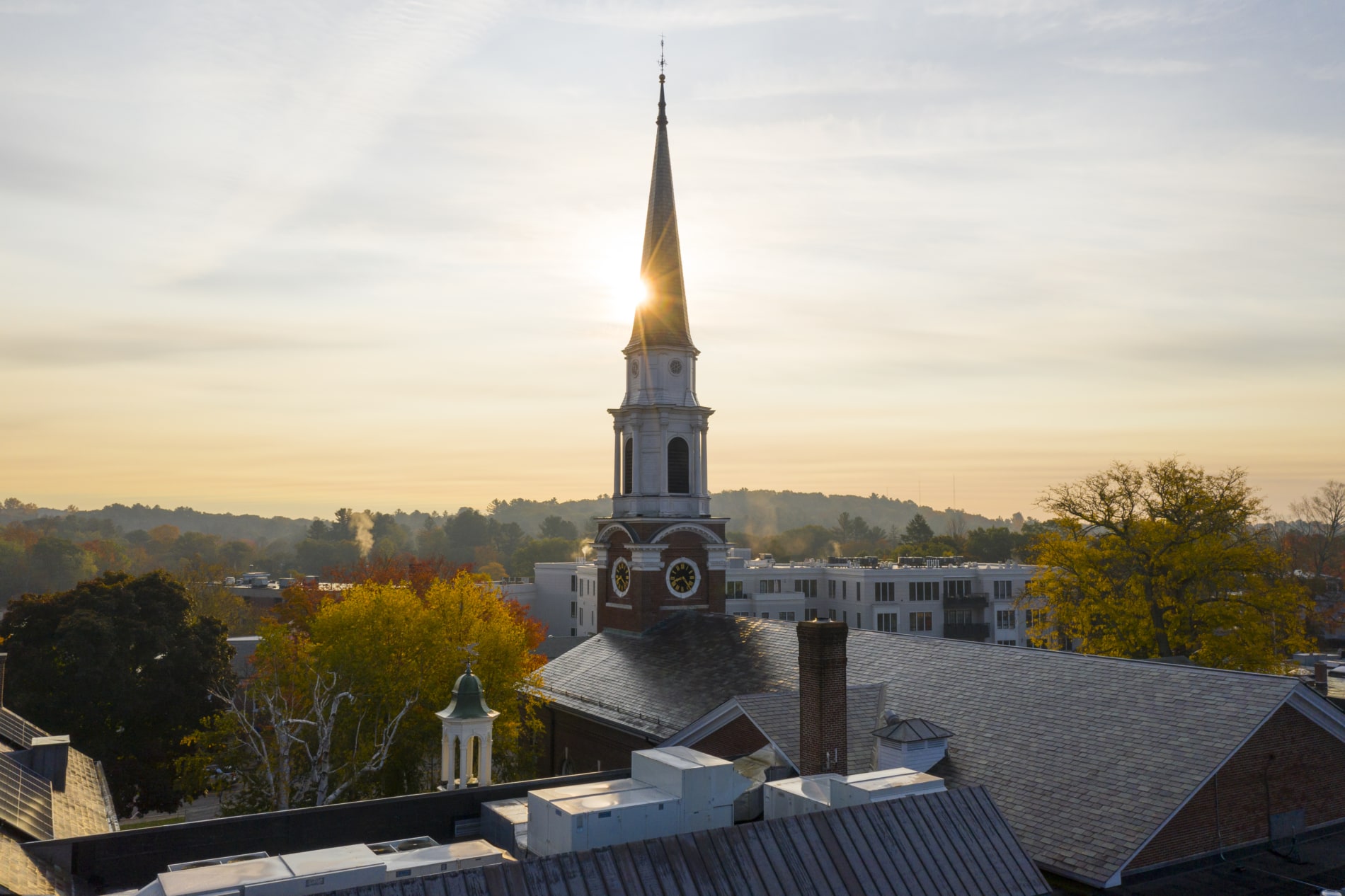 The steeple of the Wellesley Village Church towers over downtown Wellesley as the sun rises.