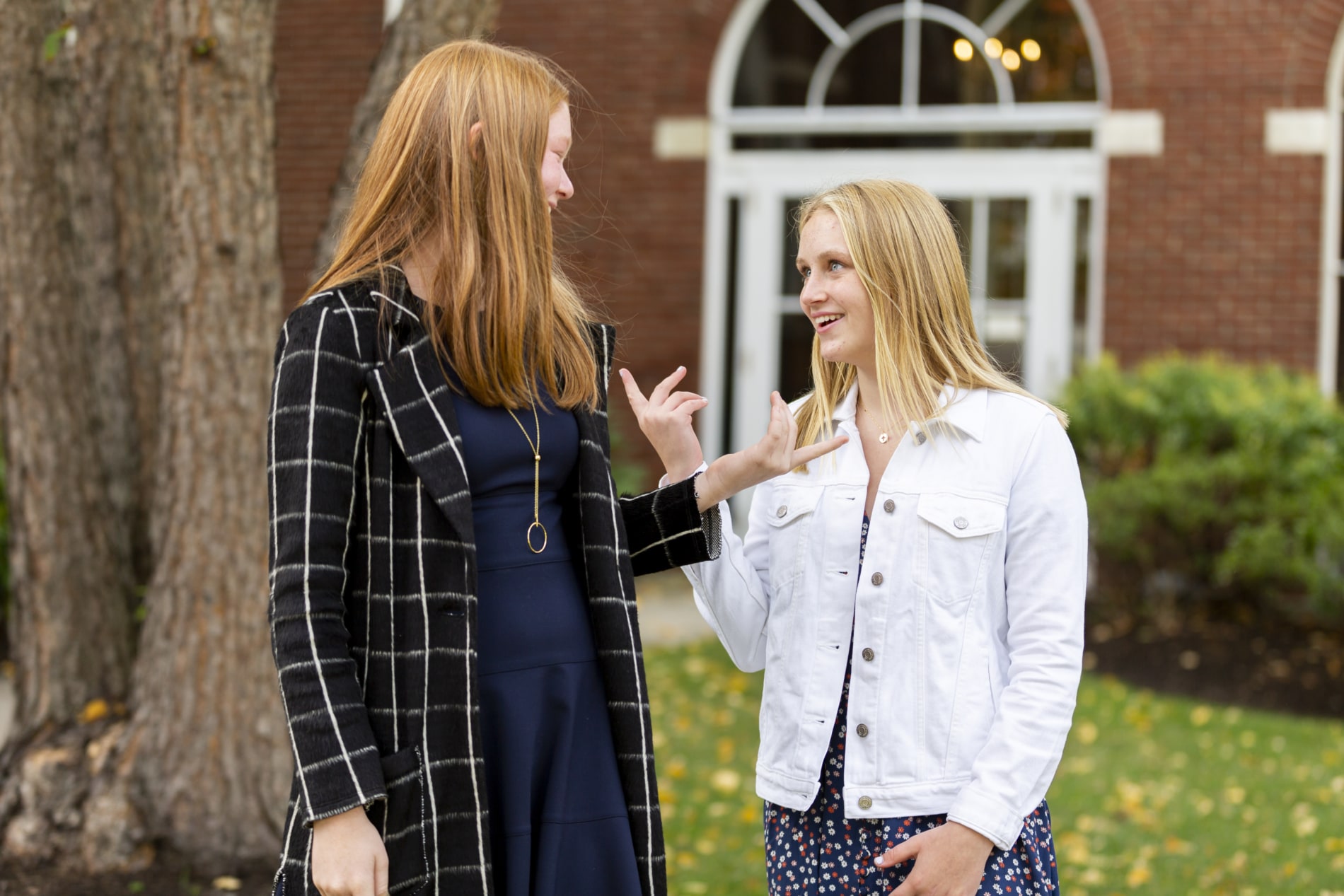 Two teenage girls talk outside of church