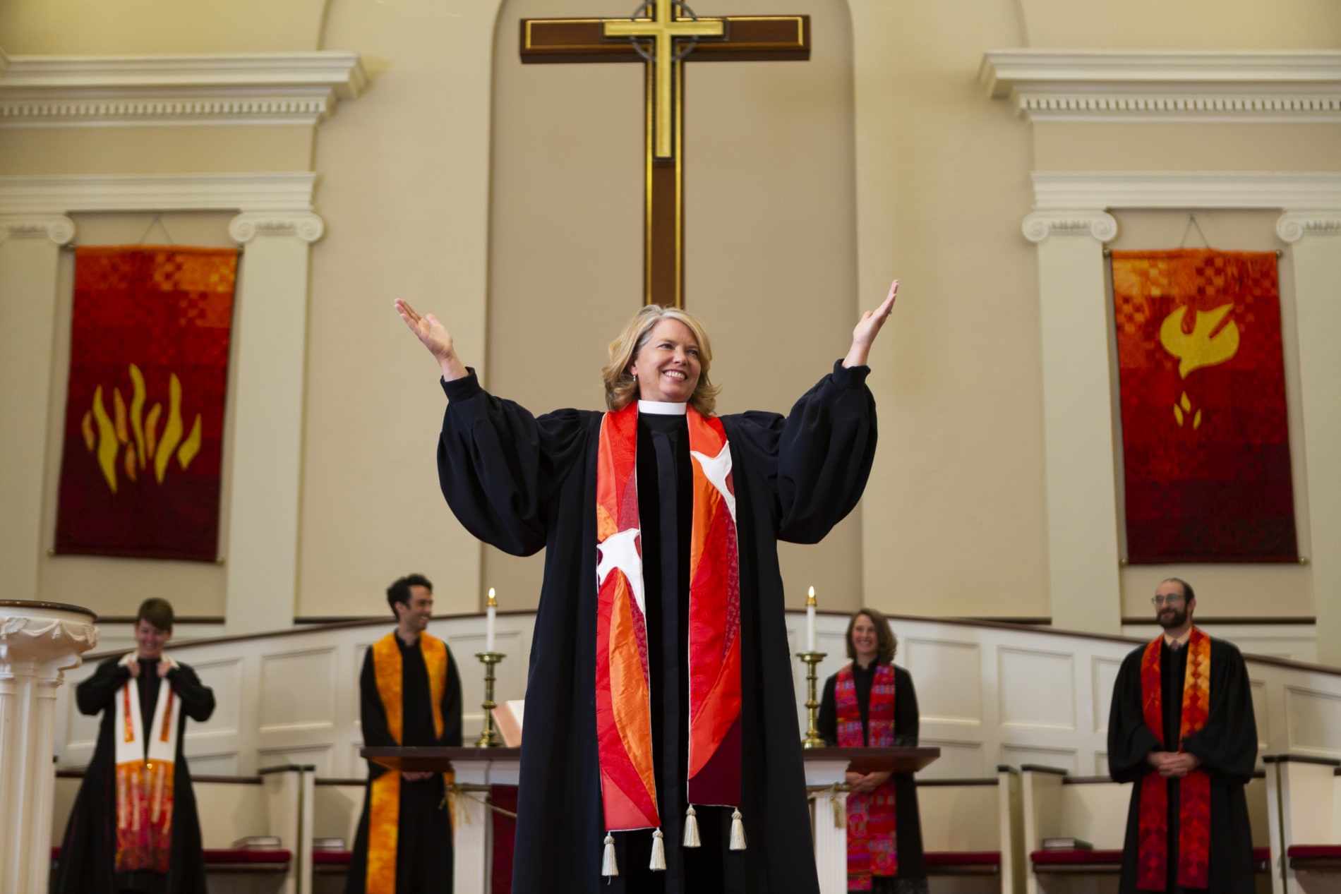 Rev. Sarah Butter lifts her hands to exhort the congregation in worship