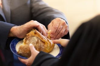 A man tears a piece of communion bread