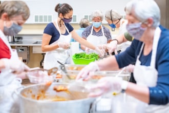 A group of folunteers preps a meal for the Village Table food program