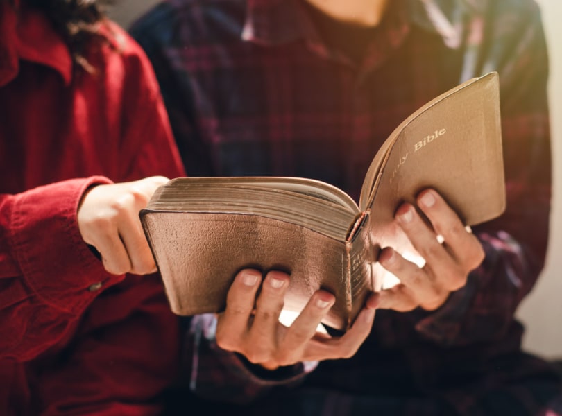 Two people are studying and reading the Bible.